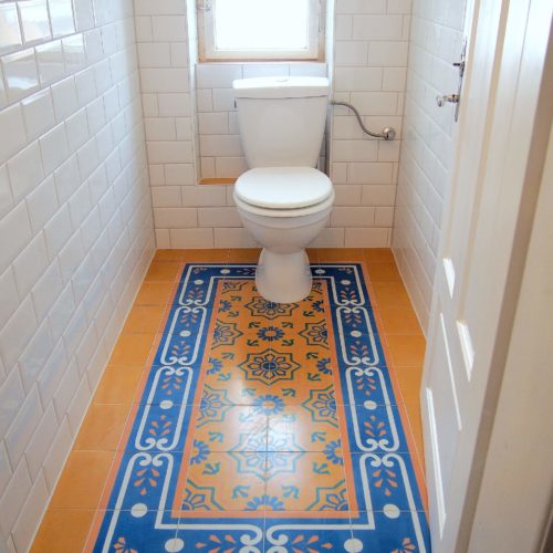 Zementfliesen im Gäste WC verlegt in einem Haus in Haiming | Muster 219, 413AB in den Farben Gelb (M05), Blau (M19), Weiß (M01) und Lachs (M10) | Referenznummer: 8823