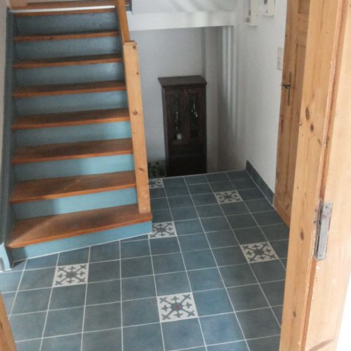 Zementfliesen im Eingang verlegt in einem Haus in Köln | Muster 121 und Unifliesen in den Farben Mahagoni (M14), Jeans (M22) und Nebel (M33) | Referenznummer: 8596 / S1199