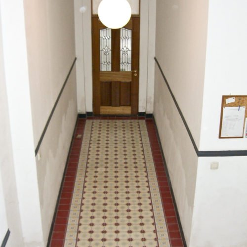 Zementfliesen im Flur verlegt in einem Haus in Köln | Muster 136 mit Bordüre 422AB und Unifliesen in den Farben Bordeaux (M13), Elfenbein (M02), Hellblau (M21) Nebel (M33) und Gelb (M05) | Referenznummer: 1508
