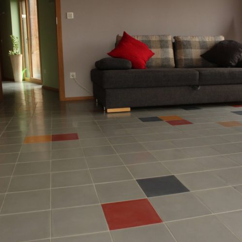 Zementfliesen im Wohnzimmer verlegt in einem Haus in Düren | Unifiesen in den Farben Stein (M30), Schiefer (M50), Grasgrün (M25), Senf (M06) und Zimt (M35) | Referenznummer: 8238 / S1142