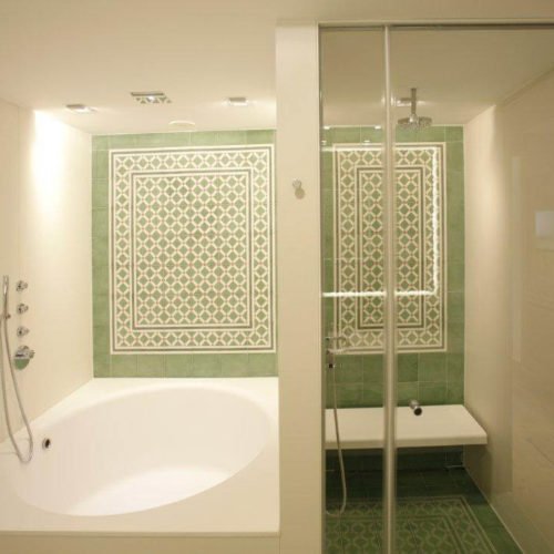 Dusche und Badewanne mit Zementfliesen (Hotel) | Muster 144, 449AB und Unifliesen in den Farben Elfenbein (M02), Tanne (M26), Grasgrün (M25) und Rot (M12) | Referenznummer: 1948