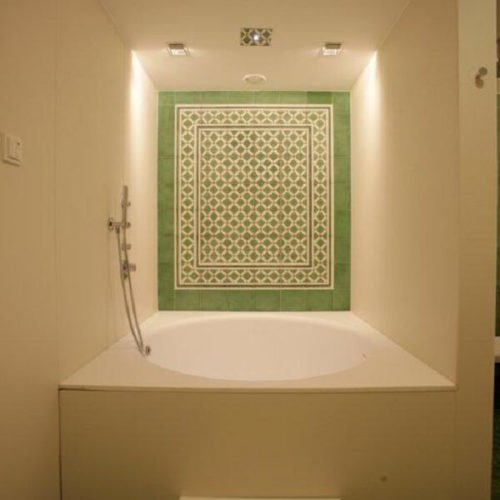 Hotel-Badewanne mit Zementfliesen | Muster 144, 449AB und Unifliesen in den Farben Elfenbein (M02), Tanne (M26), Grasgrün (M25) und Rot (M12) | Referenznummer: 1948