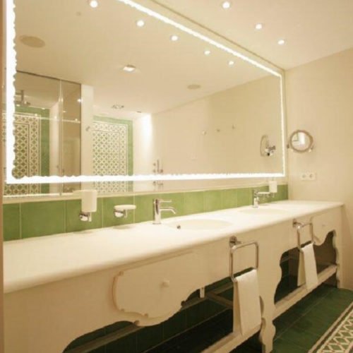 Zementfliesen im Hotel-Badezimmer - Blick durch den Spiegel | Muster 144, 449AB und Unifliesen in den Farben Elfenbein (M02), Tanne (M26), Grasgrün (M25) und Rot (M12) | Referenznummer: 1948