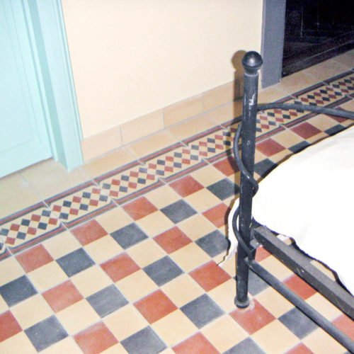 Zementfliesen im Schlafzimmer verlegt in einer Wohnung in München | Muster 483 und Unifliesen in den Farben Nachtblau (M18), Kupfer (M11) und Creme (M03) | Referenznummer: 1719