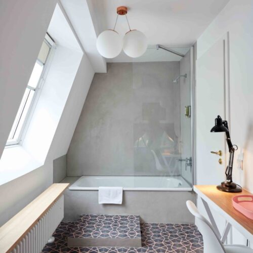 Zementfliesen verlegt im Badezimmer mit Badewanne in meinem Hotel in Köln (Architekt Martin Bachem) | Muster Penta 01 in den Farben Aubergine (M15) und Rosa (M06) | Referenznummer: S2094