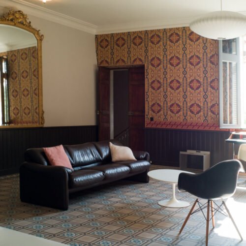Der Salon im zweiten Stock des Chateau de Sibra beeindruckt durch die historischen Muster auf der Tapete und auf den Zementfliesen von Mosáico